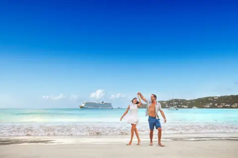 Ett lyckligt par dansar på stranden i San Juan, med ett kryssningsfartyg i bakgrunden.