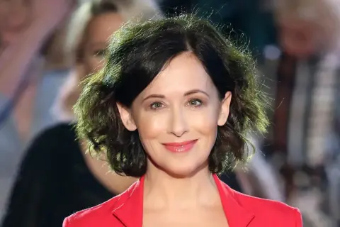 Uśmiechnięta Jolanta Fraszyńska w czerwonej marynarce, znana z wielu filmów, seriali i programów.