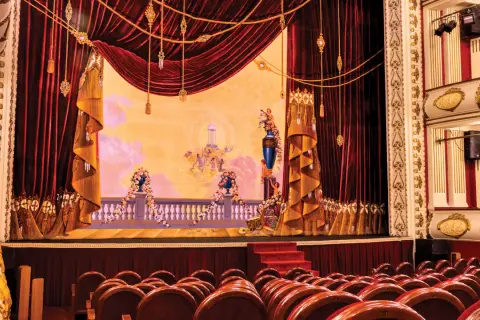 Scena Teatru Wielkiego w Warszawie, bogato zdobiona, z aksamitnymi kotarami i malowidłem przedstawiającym anioły.