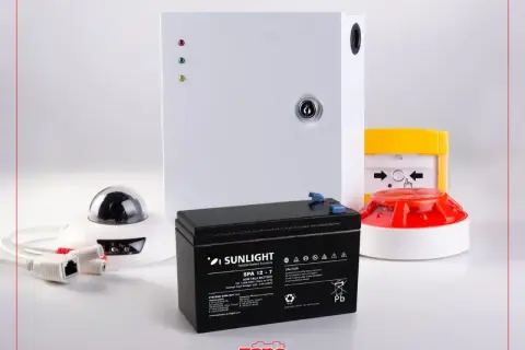 Batterie pour alarme filaire, assurant une longue durée de vie. Composants de sécurité visibles : caméra, sirène, centrale.