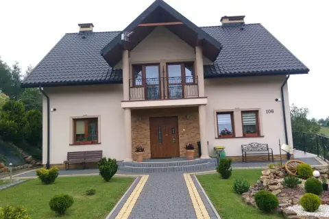 Piękny dom w Brzeźnicy z zadbanym ogrodem, kamienną ścieżką i ozdobnym kamiennym skalniakiem.