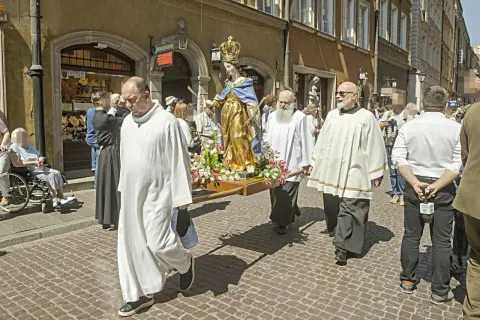 Procesja z figurą Matki Boskiej. Czy w Boże Ciało trzeba iść do kościoła? Wierni niosą figurę ulicą, niektórzy w strojach duchownych.