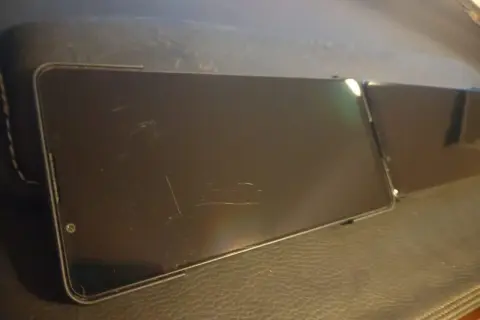 Deux smartphones posés sur une surface en cuir. L'un d'eux, avec un écran en Gorilla Glass Victus 2, présente quelques rayures.
