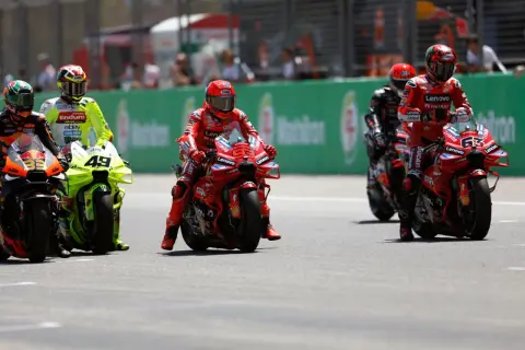 Pilotos de MotoGP en la parrilla de salida, listos para un intenso motogp test. El número 63 de Ducati destaca.
