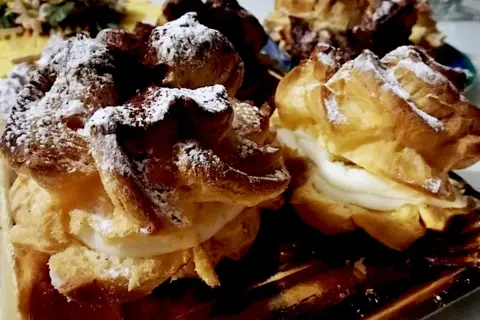 Dolci "teste di turco" con crema soffice e zucchero a velo, un piacere per gli occhi e il palato.