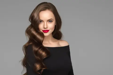 Mujer con peinados ondas media melena, labios rojos y vestido negro.