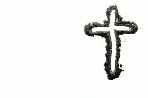 Krzyż z zielonego proszku, symbolizujący życie i wiarę, na tle pustki. Czy inseminacja może być zgodna z naukami kościoła?