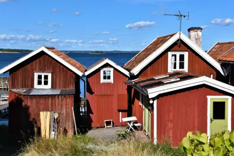 Röda stugor vid vattnet, en idyllisk vy från Sandhamn camping.