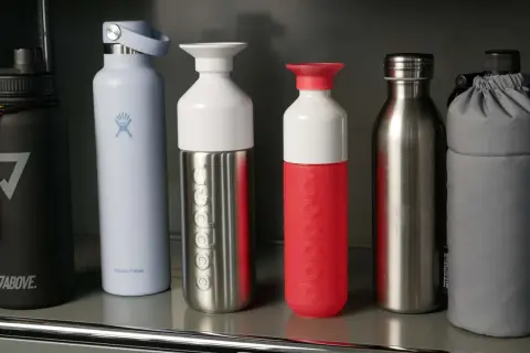 Sechs Trinkflaschen in verschiedenen Farben und Materialien, darunter ein Testsieger für Sport.