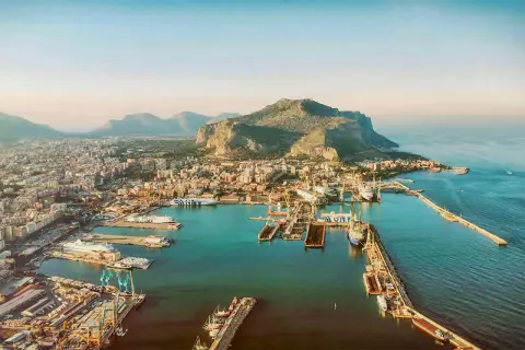 Palermo mit Kindern: Ein Blick auf den Hafen mit Schiffen und dem Monte Pellegrino im Hintergrund. Perfekt für einen Familienausflug!