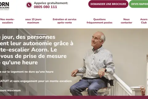 Un homme âgé sourit sur un monte-escalier Acorn, retrouvant son autonomie. Obtenez un devis gratuit pour votre monte-escalier.