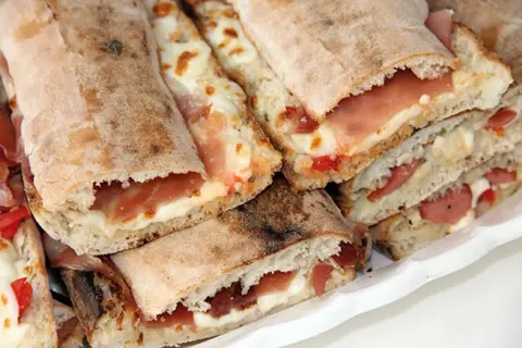 Paposcia come farcirla: focaccia ripiena di prosciutto e formaggio fuso, un'idea gustosa per un pasto veloce.