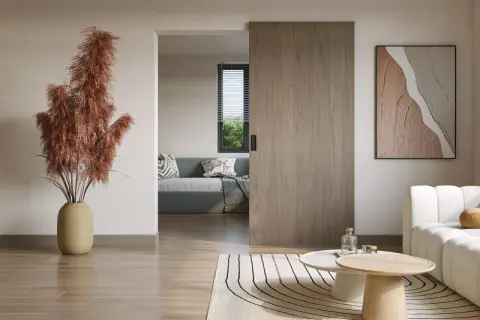 Instalar puerta corredera de madera en un salón moderno. Un jarrón con pampas secas decora el espacio.
