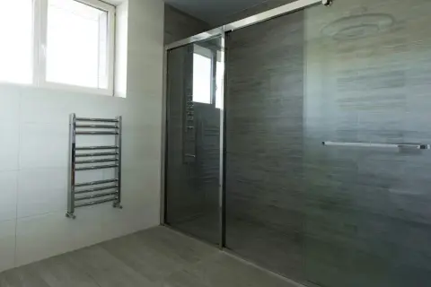 Modernes Bad mit Dusche und Handtuchwärmer. Die **bad elektroheizung** sorgt für wohlige Wärme.