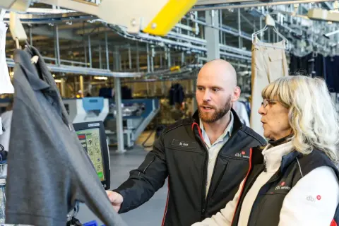 Mitarbeiter besprechen den gwe tarifvertrag bei der Arbeit in einer Wäscherei.