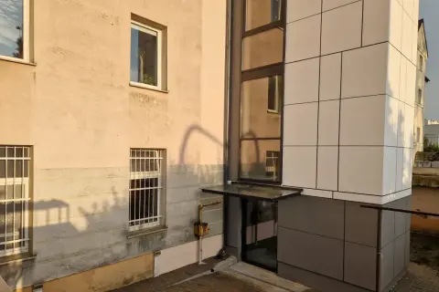 Nowoczesny blok z jasną elewacją i przeszklonym wejściem. Poznaj, jak zapisać adres mieszkania w bloku, by listonosz go odnalazł.
