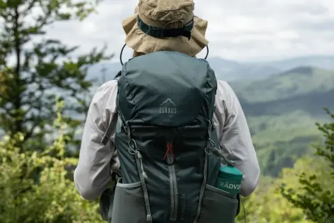 Osoba w kapeluszu z plecakiem Elbrus Moonhill 30 podziwia górski krajobraz.