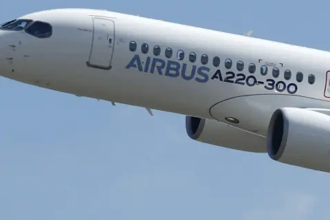 Biały samolot Airbus a220-300 wznosi się na błękitne niebo.