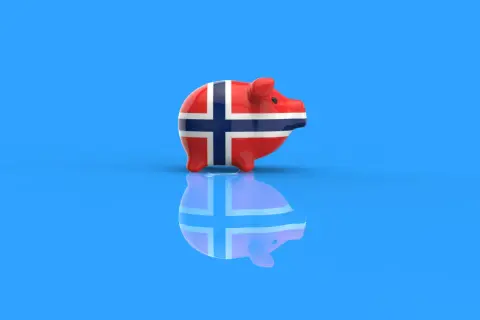 Skarbonka w barwach flagi Norwegii, symbolizująca konto walutowe w koronach norweskich.
