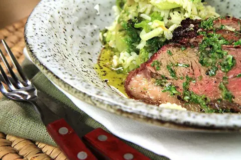 En saftig picanha, perfekt grillad, serveras med ris och grönsaker. En härlig måltid att njuta av.