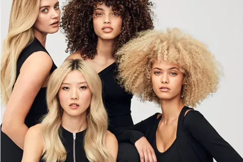 Fyra kvinnor med olika hårtyper: rakt, lockigt och afro. Alla har slitet hår som ser friskt ut.