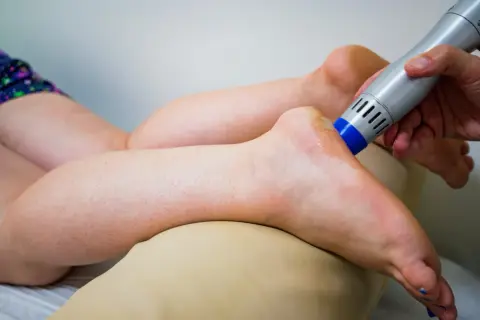 Behandlung eines Fußes mit einem Ultraschallgerät, um neurologische Ursachen für Krallenzehen zu lindern.
