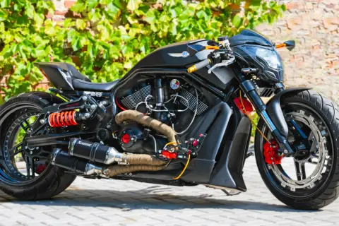 Czarny, sportowy motocykl z pomarańczowymi akcentami i podwójnym wydechem Akrapovič. Ten monowahacz to marzenie każdego fana motoryzacji.