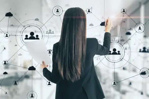 Kobieta analizuje schemat sieci kontaktów, szukając nowych **trendów na rynku pracy**.