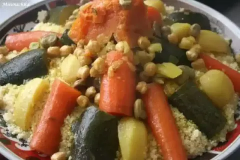 Un plat coloré de recette couscous avec carottes, courgettes, pois chiches et pommes de terre.