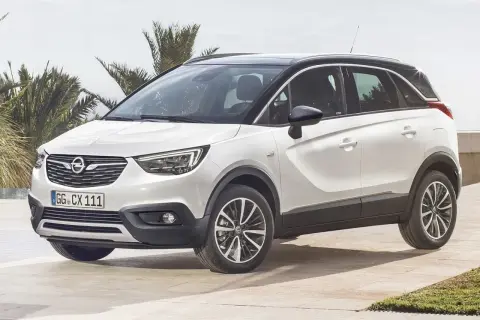 Biały Opel Crossland z czarnym dachem, zaparkowany na tarasie z palmami w tle. Wiele pozytywnych opinii o tym modelu.
