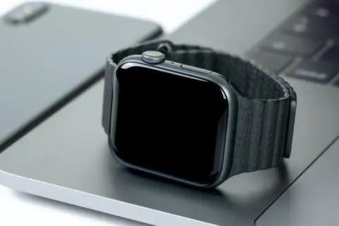 Smartwatch nie działa wyświetlacz. Czarny ekran zegarka na tle laptopa i telefonu.