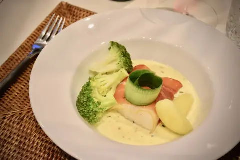 En vacker tallrik med fisk, broccoli och potatis i en krämig sås. Perfekt för en middag med vin till Sandefjordsås.