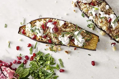 Gefüllte Auberginen mit Couscous, Granatapfelkernen und Minze. Ein köstliches Gericht, um Aubergine zuzubereiten.