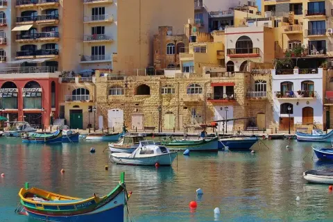 Malta, z kolorowymi łodziami i kamiennymi budynkami. Czy na Maltę potrzebny paszport? Tak, jeśli nie jesteś obywatelem UE.