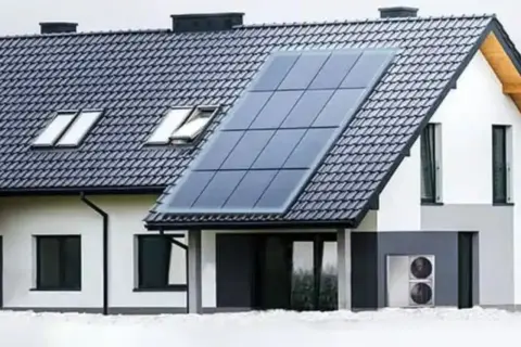 Nowoczesny dom z panelami słonecznymi na dachu. System fotowoltaiczny zapewnia energię, chroniąc przed blackoutem.
