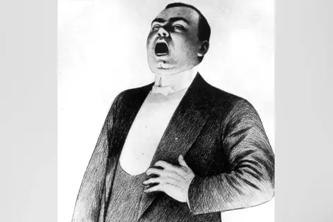 Caruso tenor w szczytowym momencie arii, z otwartymi ustami i dłonią na piersi.
