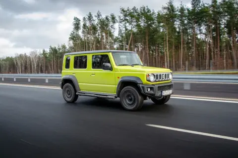Jaskrawozielony suzuki jimny 5-drzwiowy na drodze. Sprawdź suzuki jimny 5-drzwiowy cena i możliwości.