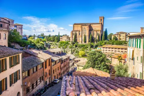 Un panorama mozzafiato di Siena, una gemma della Toscana da visitare, con la maestosa Basilica di San Domenico che domina il paesaggio urbano.
