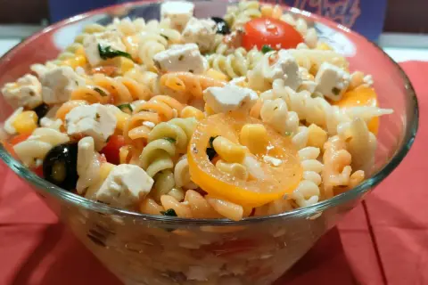 Kolorowa sałatka z makaronem fusilli, serem feta, oliwkami, kukurydzą i pomidorkami. Idealna na letnie dni.
