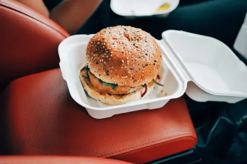 Pyszny burger w białym opakowaniu, idealny na szybki posiłek. Czy zastanawiałeś się nad big mac kalorie?