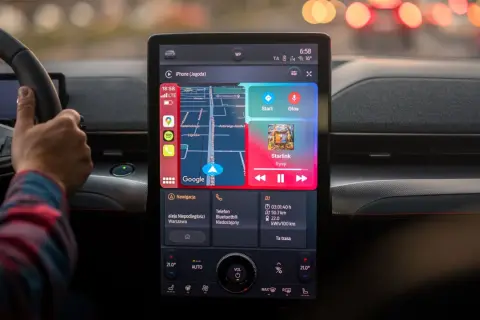 Włączanie android auto w samochodzie. Na ekranie nawigacja Google, Spotify i odtwarzacz muzyki.