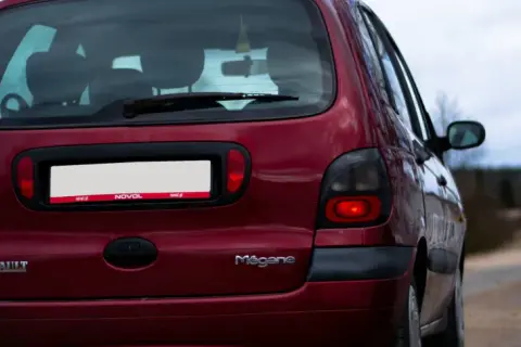 Czerwony Renault Megane z widocznym wycieraczką tylną. Jak wyłączyć tylną wycieraczkę? Sprawdź instrukcję obsługi.