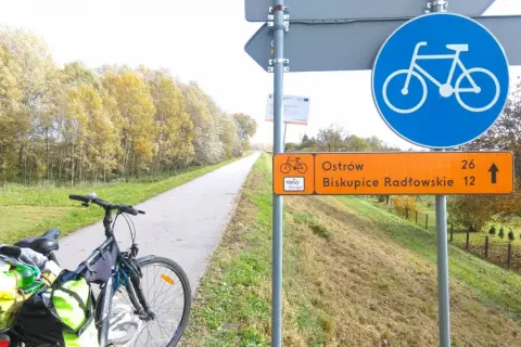 Rower gotowy do podróży po trasach rowerowych Tarnów. Jesienne liście i drogowskaz wskazują kierunek.