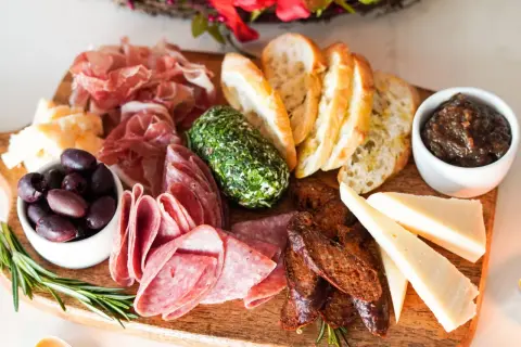 Planche apéro gourmande : charcuteries fines, fromages variés, olives, pain grillé, confiture de figues et fromage frais aux herbes. Une belle idée pour un moment convivial.