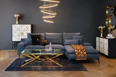 Nowoczesny, **soft loft salon** z szarą sofą, złotym stolikiem kawowym i designerską lampą.