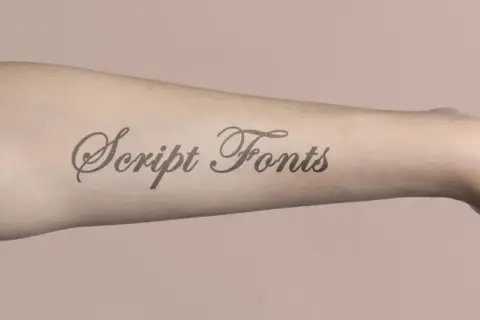 Ein Arm mit einem Tattoo-Schriftzug "Script Fonts". Diese elegante Schriftart eignet sich perfekt für Namen-Tattoos.