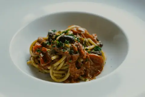 En portion spaghetti med en smakrik tomatsås, oliver och kapris. Perfekt vin till pasta puttanesca.
