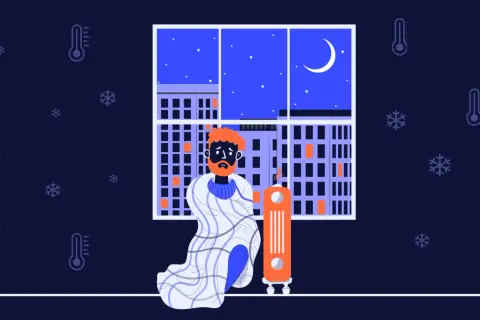 En man med orange hår och skägg sitter insvept i en filt bredvid en element. Utanför fönstret syns en stad i mörker med snöflingor och termometrar som visar att det är kallt i huset.