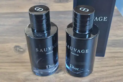 Dwa flakony Dior Sauvage Parfum 100ml, każdy z czarną zakrętką z logo CD.