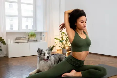 Frau dehnt sich mit ihrem Hund, um gelenkiger zu werden.